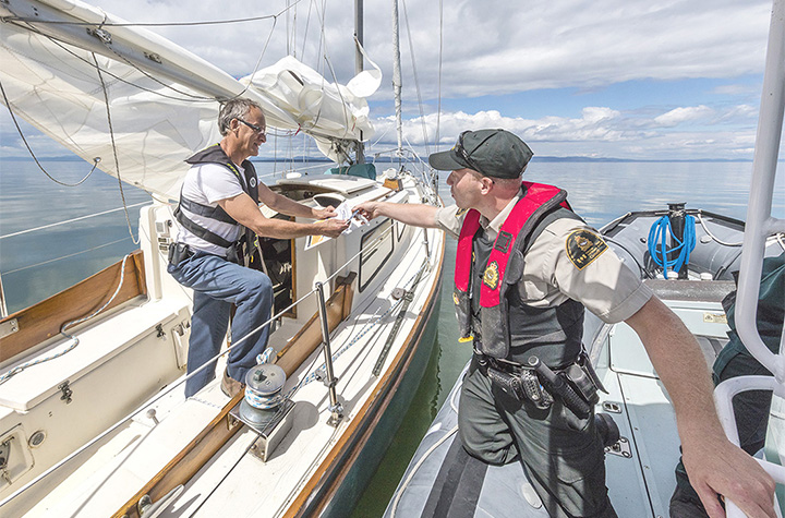 During a patrol at sea, a fishery officer takes the opportunity to inform a boater about the navigation rules related to the presence of marine mammals.