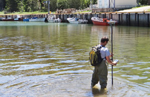 Un hydrographe effectue un relevé bathymétrique d'un secteur peu profond d’un havre de pêche.