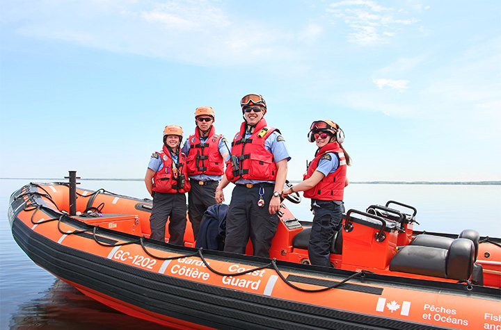 Two men and two women, forming a crew, on board an inshore rescue boat.