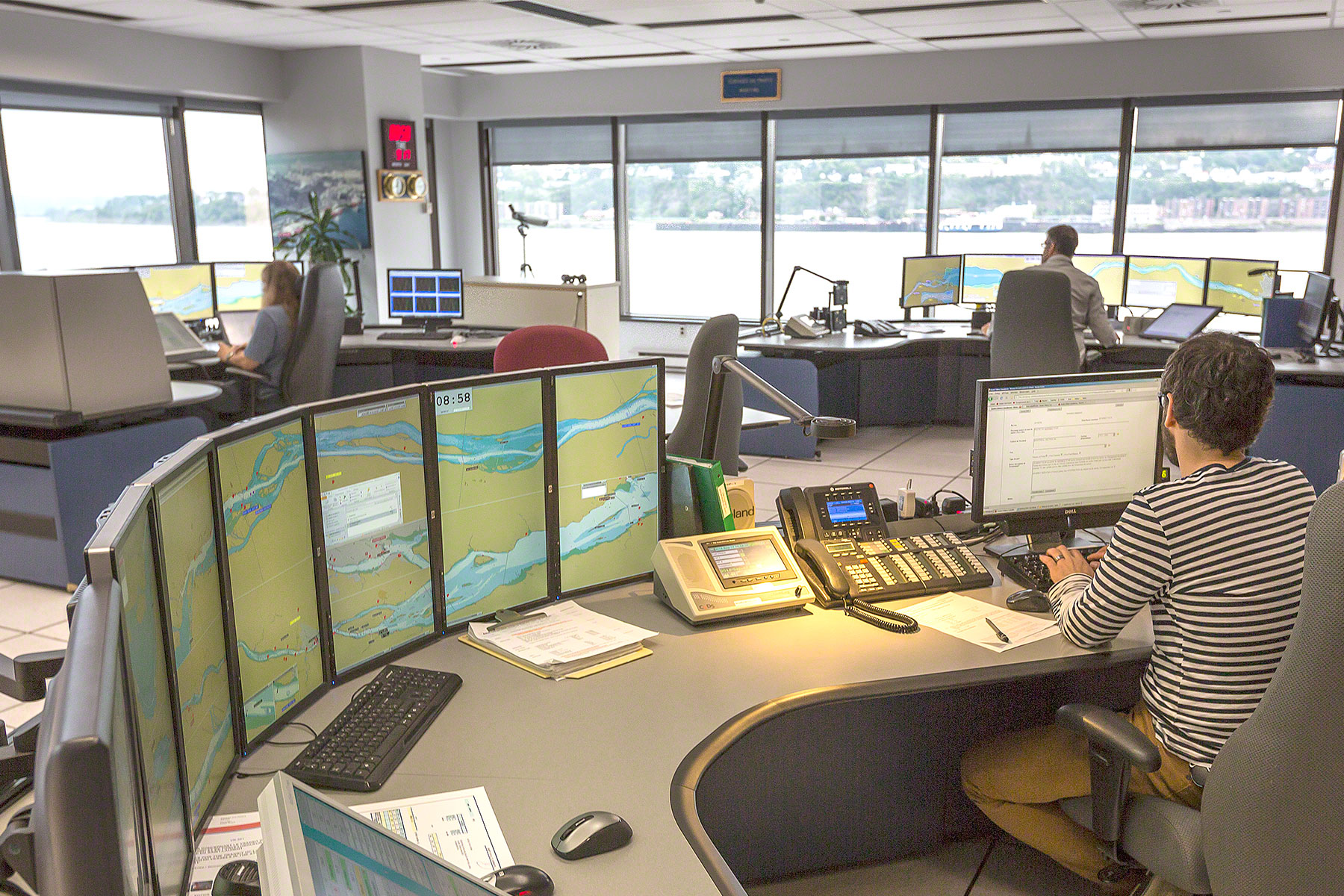 Intérieur du centre de Services de communication et de transport maritime à Québec, avec plusieurs écrans d'ordinateur