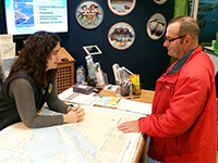 Au stand du Service hydrographique du Canada, une hydrographe discute avec un visiteur