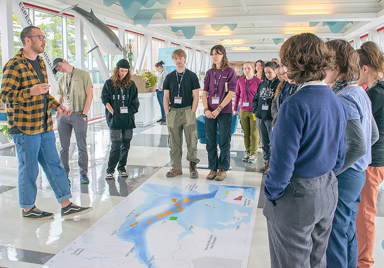 A guide showing a map on the floor during a visit.