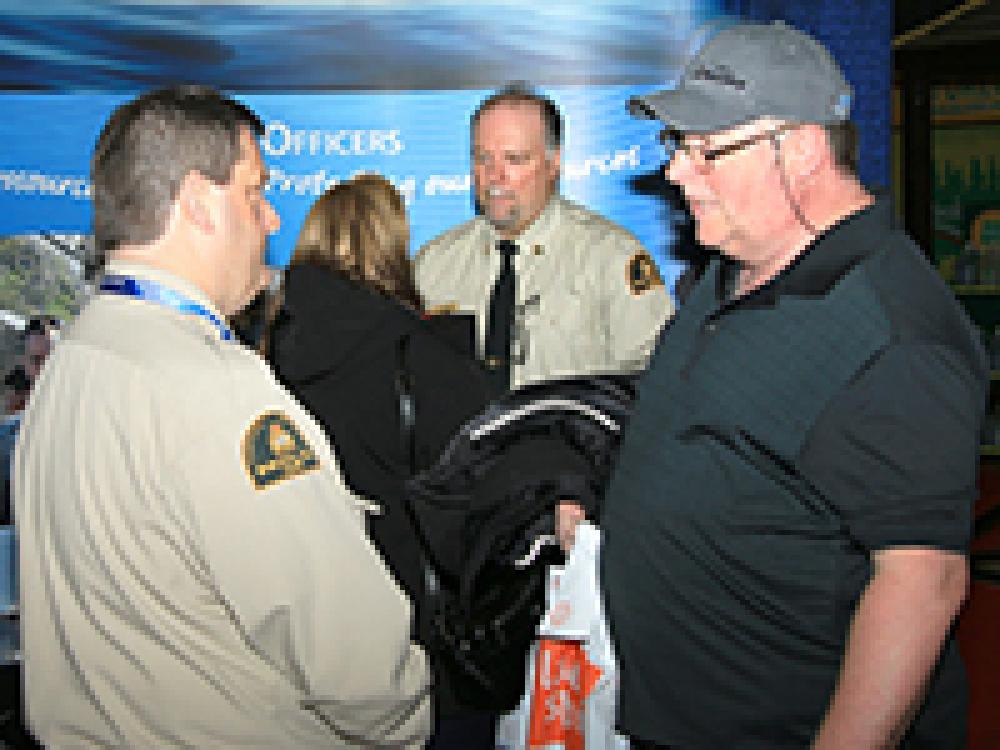 Two fisheries officers talking with visitors at the Fisheries and Oceans Canada booth