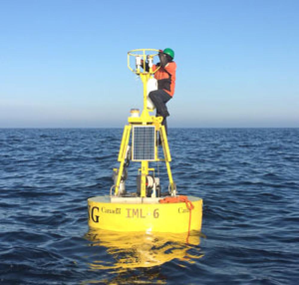 Homme debout effectuant des travaux d'entretien sur une bouée scientifique