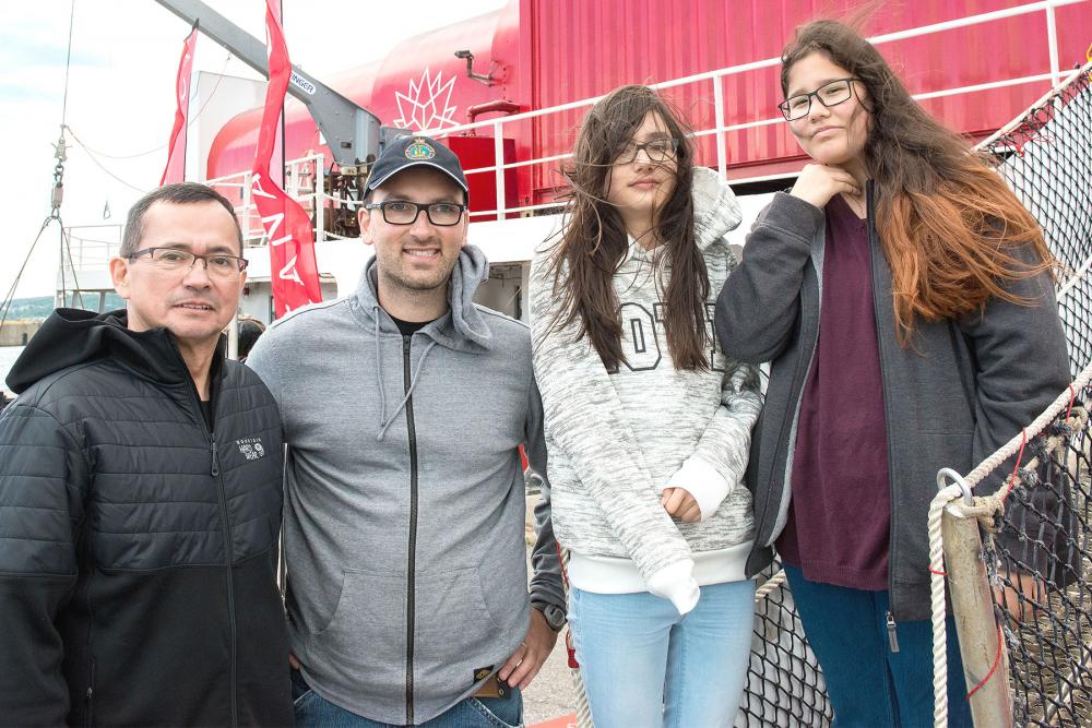 Photo showing Yann Côté Nadeau with teacher Alain Rock and two Innu students