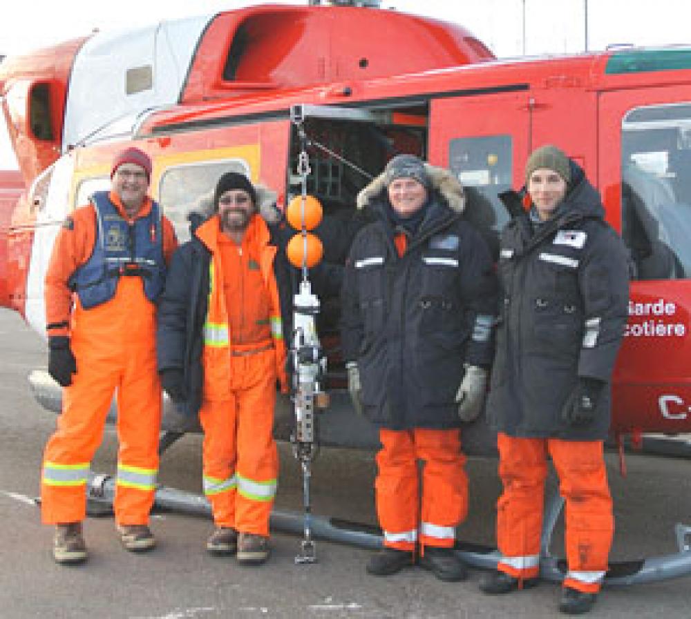 L’équipe d’échantillonnage en mars 2014 (de gauche à droite) : le chercheur et chef du projet Peter Galbraith, le technicien en océanographie Rémi Desmarais, le pilote Robert Delisle et le technicien d’aéronef David Gauvin. La sonde utilisée est au centre du groupe.