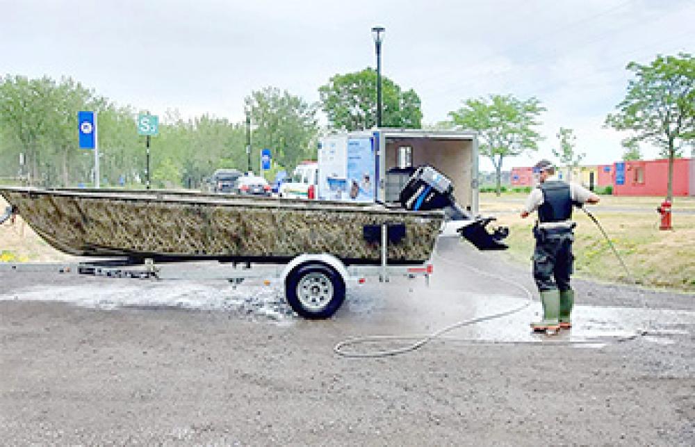 Un agent des pêches nettoie un bateau