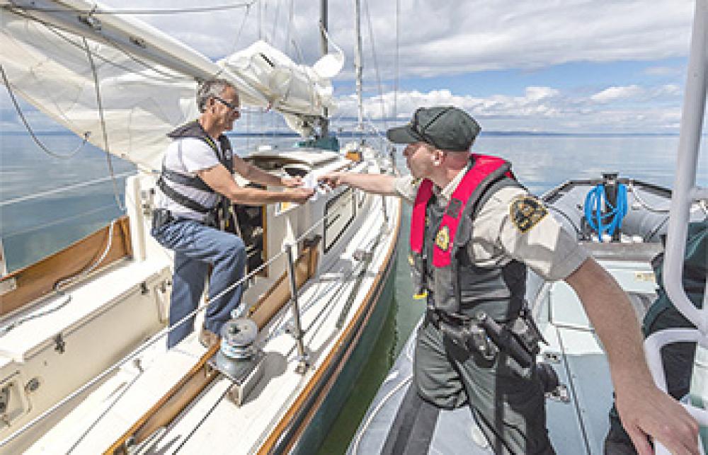 Lors d’une patrouille en mer, un agent des pêches rencontre un plaisancier pour l’informer des règles de navigation à adopter en présence de mammifères marins.