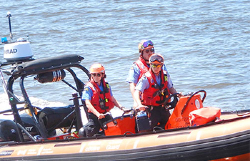 Crew of an inshore rescue boat in action on the water.