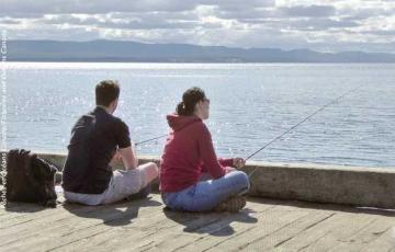 Deux personnes qui pêchent à partir d'un quai. 